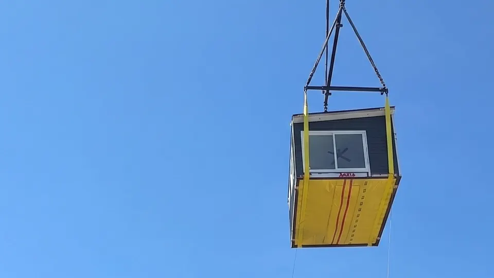 A Framework First module suspended from a crane