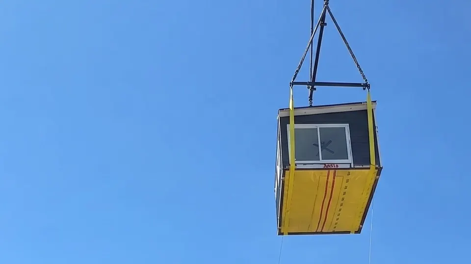 A finished Framework First home being craned into a backyard